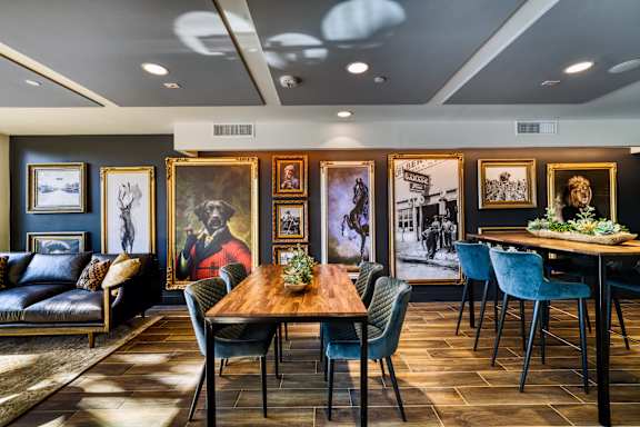 A dining room with a wooden table surrounded by chairs.