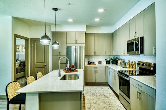 A modern kitchen with a large island and stainless steel appliances.