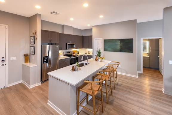 A modern kitchen with wooden floors and a central island.