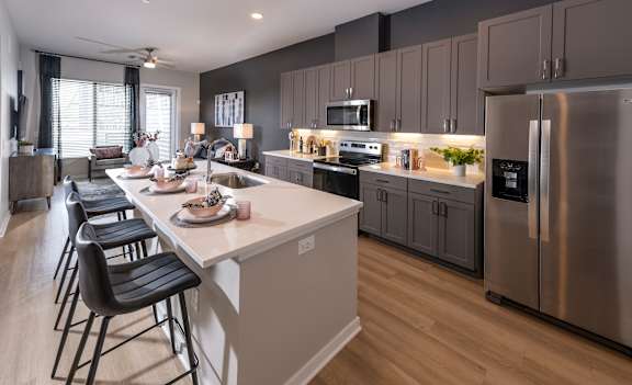 A modern kitchen with a large island and stainless steel appliances.