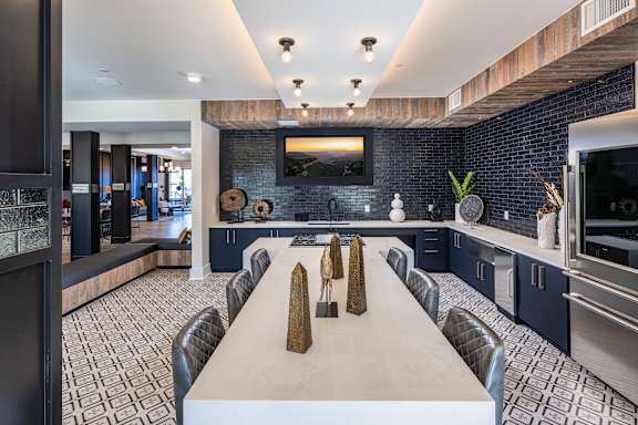 A modern kitchen with a long table and chairs.