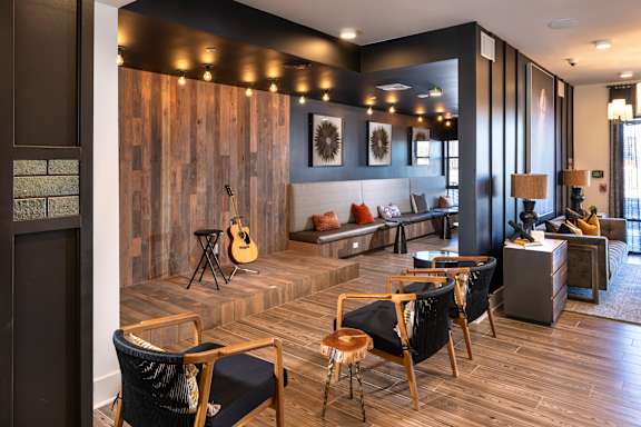 A room with a guitar and chairs.