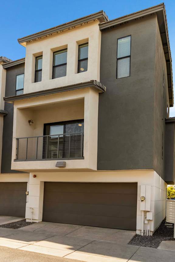 A modern two-story house with a balcony on the second floor.