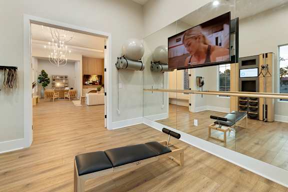 A room with a bench and a television mounted on the wall. at Villas on Ash Apartments, Arizona