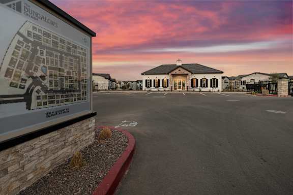 A sign for Bungalow's sits in front of a building with a parking lot in the foreground. at Villas on Ash Apartments, Gilbert, AZ, 85234