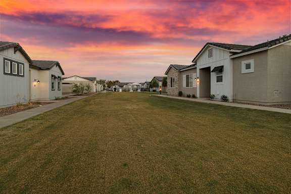 A row of houses with a grassy lawn in the foreground. at Villas on Ash Apartments, Arizona, 85234