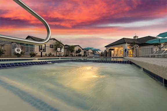 A swimming pool with a sunset in the background at Villas on Ash Apartments, Gilbert, AZ, 85234