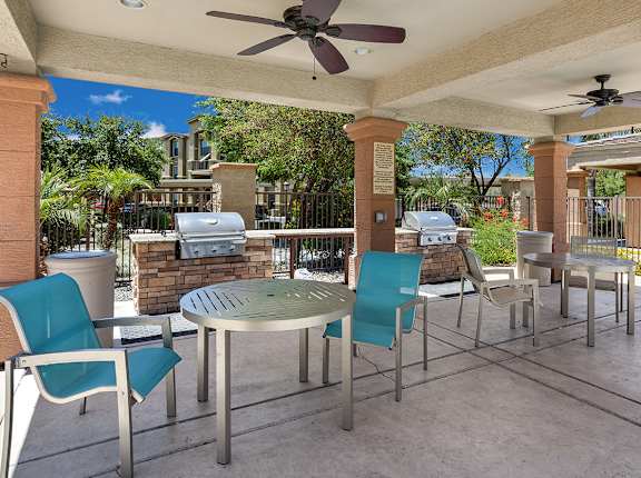 A patio with a table and chairs under a roof. at Superstition Canyon Apartments, Arizona, 85209