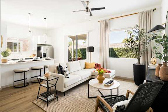 A modern living room with a white sofa, a black chair, and a coffee table. at Villas on Ash Apartments, Arizona, 85234