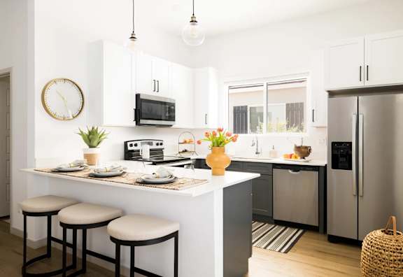 A kitchen with a white counter and a fridge. at Villas on Ash Apartments, Arizona