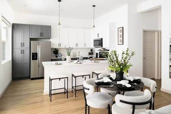 A modern kitchen with a dining table set for four. at Villas on Ash Apartments, Gilbert, 85234