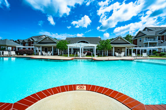 a large swimming pool with houses in the background