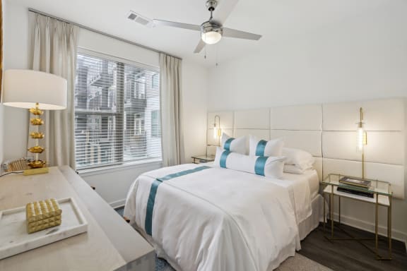 a white bedroom with a large bed and a ceiling fan