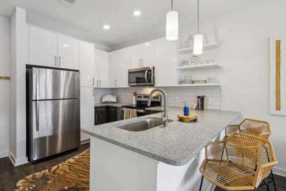 a kitchen with white cabinets and a granite counter top and a stainless steel refrigerator