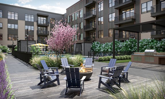 a patio with chairs and a fire pit in front of an apartment building at Link Apartments® Broad Ave, Memphis, Tennessee
