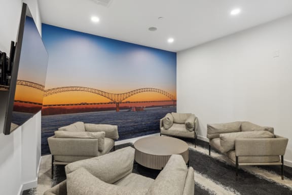 a living room with couches and a wall mural of a bridge at Link Apartments® Broad Ave, Tennessee