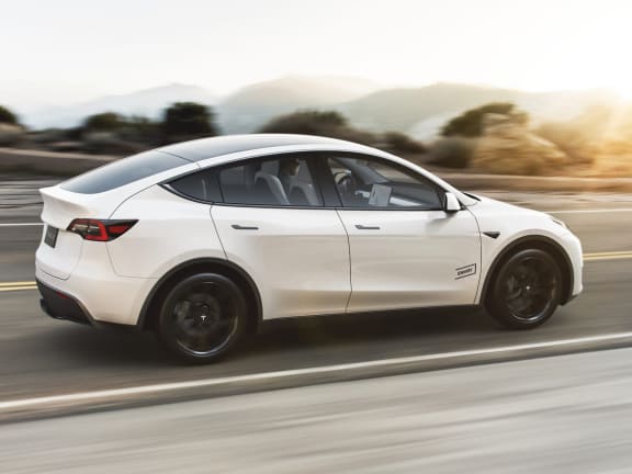 a white tesla car driving down a road at Link Apartments® Montford, Charlotte