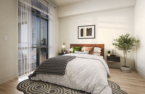 a bedroom with a bed and a sliding glass door to a balcony at Link Apartments® Four 12, Oakland, 94607