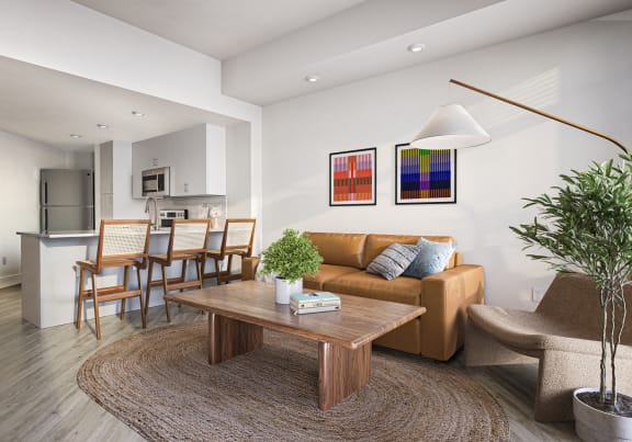a living room with a couch and a coffee table in front of a dining room at Link Apartments® Four 12, California, 94607