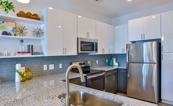 Modern kitchen with glass backsplash  at Link Apartments® Montford, Charlotte, North Carolina