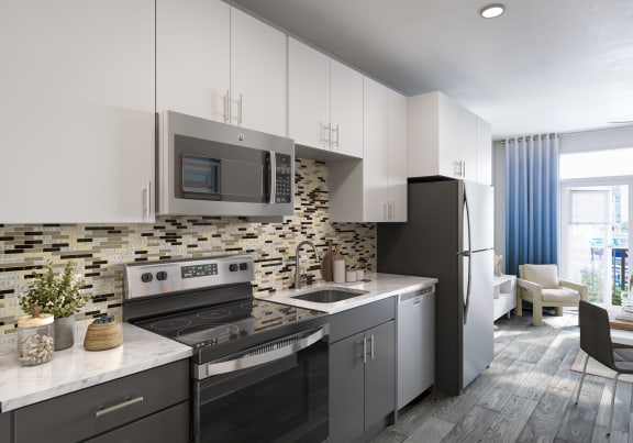 a kitchen with white cabinets and a black stove top oven  at Link Apartments&#xAE; Mint Street, North Carolina, 28203