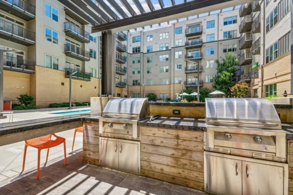 an outdoor kitchen with a grill and a pool in an apartment building at Link Apartments Innovation Quarter, North Carolina, 27101
