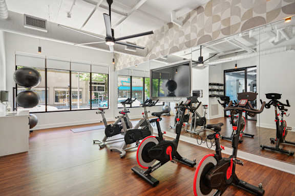 A room with a row of stationary bikes. at Link Apartments® 4th Street, Winston-Salem, North Carolina