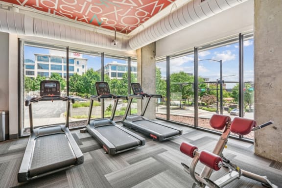 a gym with cardio machines and a view of the city at Link Apartments Innovation Quarter, Winston Salem, 27101