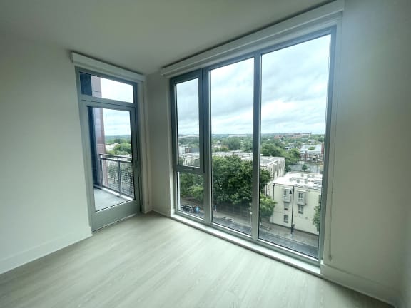 a living room with large windows and a view of the city  at Link Apartments® H Street, Washington, DC, 20002