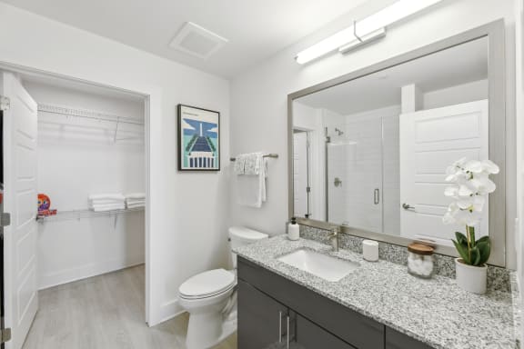 a bathroom with a large mirror and a toilet and a sink  at Link Apartments® H Street, Washington