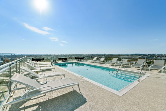 a swimming pool with chaise lounge chairs on top of a building  at Link Apartments® H Street, Washington