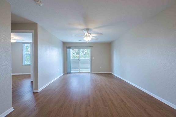 A room with wooden floors and a ceiling fan.