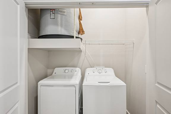 A white washing machine and dryer in a small laundry room.