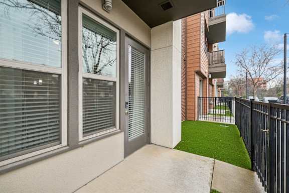 A balcony with a metal railing and a green lawn.