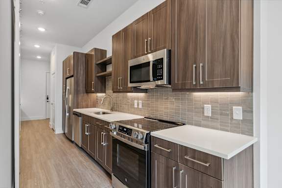 A modern kitchen with wooden cabinets and stainless steel appliances.
