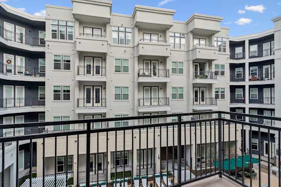 Apartment building with balconies and a pool.
