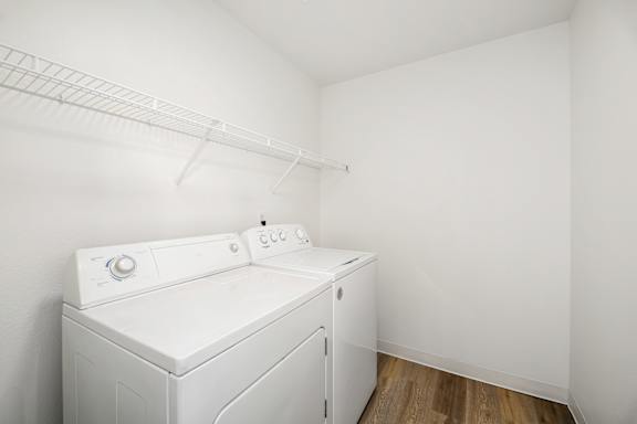 A white washing machine in a small white room.
