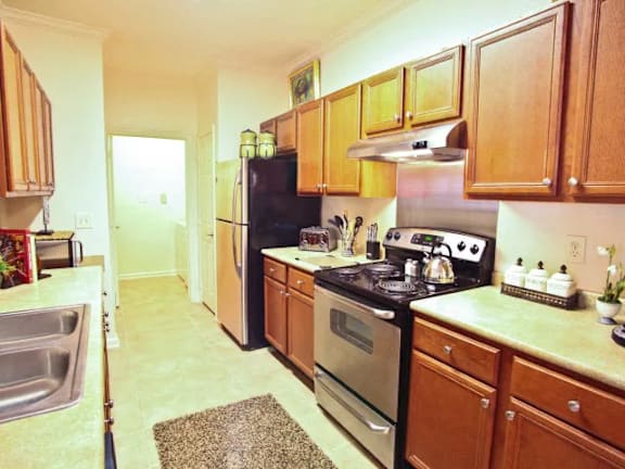 A kitchen with wooden cabinets and a black refrigerator.