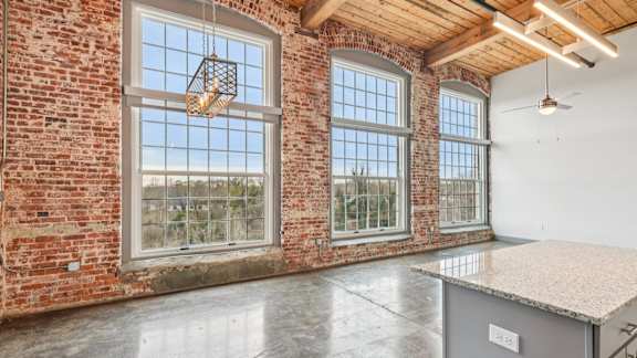 A room with a brick wall and a large window.