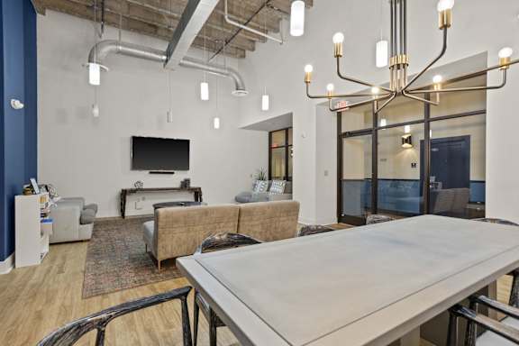 A modern living room with a large table and a television.
