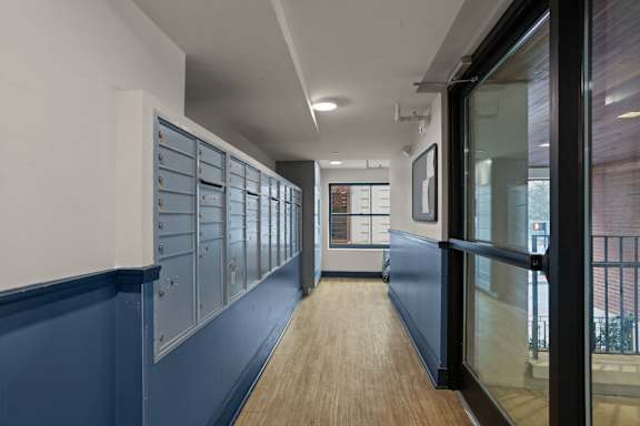 A long hallway with blue walls and wood floors.