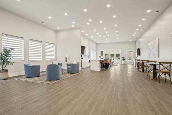 A spacious room with wooden floors and furniture.