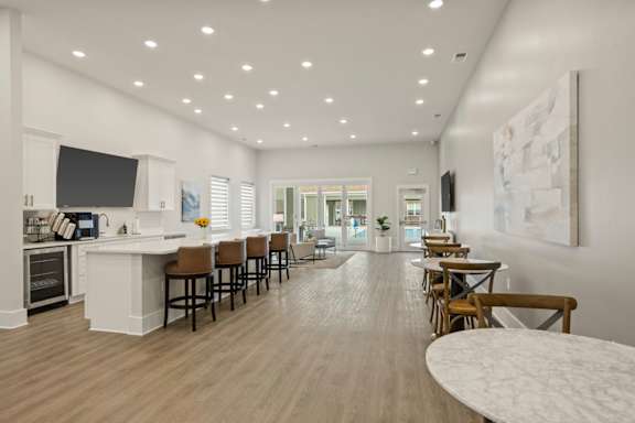 A modern kitchen with a long bar and a dining table.