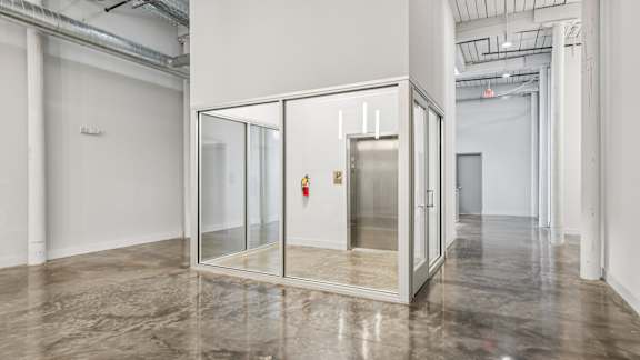 A room with a glass door and a fire extinguisher on the wall.