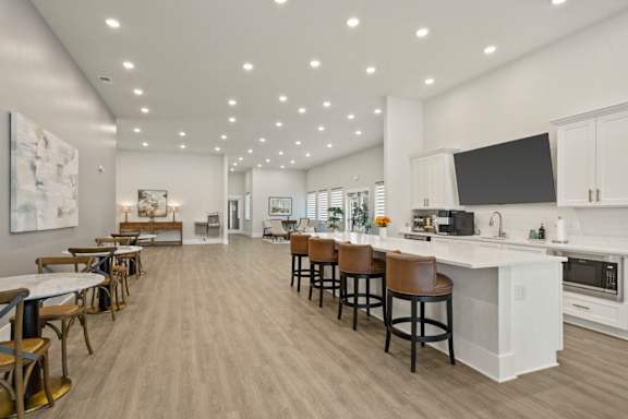 A modern kitchen with a bar area and a dining table.