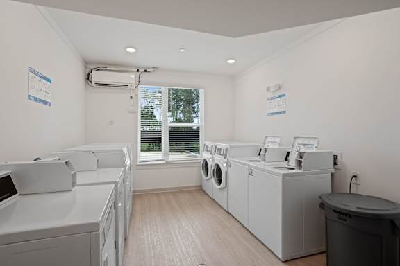 A laundry room with washing machines and a window.