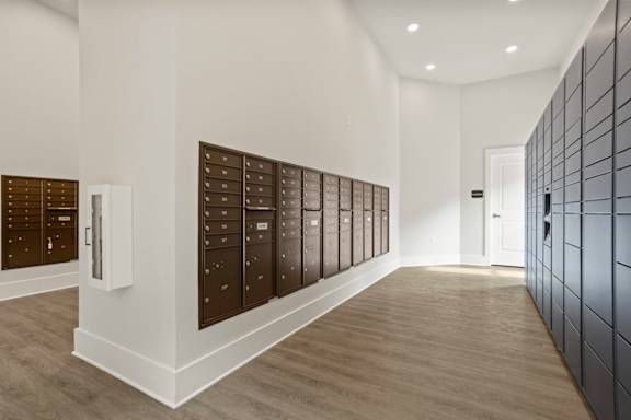 A hallway with a row of mailboxes on the wall.