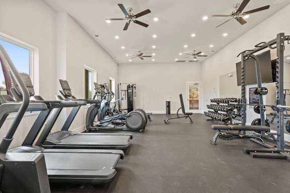 A spacious gym with treadmills, elliptical machines, and weightlifting equipment.