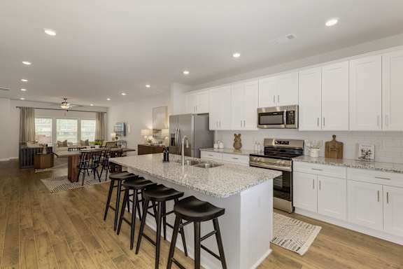 Open concept kitchen with island seating and white cabinets at The Courts at Maverick Yards Apartments, Mauldin, SC 29662