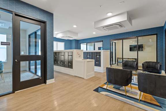 A modern office lobby with black chairs and a wooden floor.